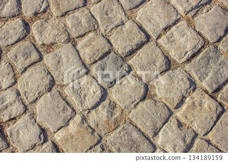 Cobblestone pavement background. Pavement road background. Bricks road. Brick surface background. Rough brick road Textured background. Sidewalk. Old cobblestone road. Cobblestone pavement background. Pavement road background. Bricks road. Brick surface background. Rough brick road Textured background. Sidewalk. Old cobblestone road. 134189159