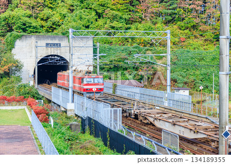 秋日里,一列貨運列車正駛過青森縣東津輕郡的青函隧道。 秋日里,一列貨運列車正駛過青森縣東津輕郡的青函隧道。 134189355