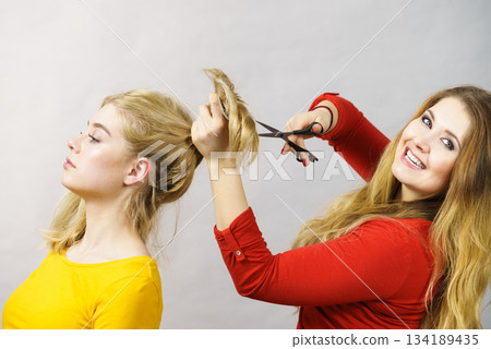 Woman getting haircut from her friend 134189435