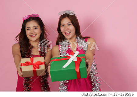 Party Fun. Friends posing with gifts and smiles at a vibrant celebration. 134189599