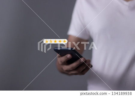 Review Customer, Young Man hand using smartphone mobile with five star to review and give 5 stars with very good results in service, Good review 5 star rating choice feedback 134189938