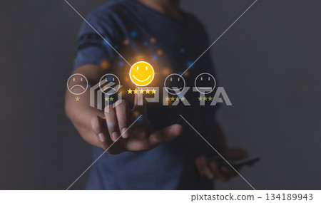 Review Customer, Young Man with smartphone hand touching emoji five star to review and give 5 stars with very good results in service, Good review 5 star rating choice feedback 134189943