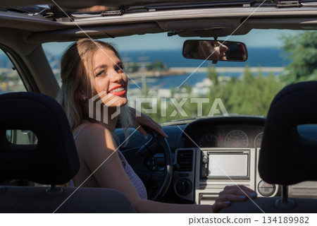 Young driver woman behind steering wheel Young driver woman behind steering wheel 134189982