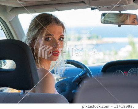 Young driver woman behind steering wheel Young driver woman behind steering wheel 134189983