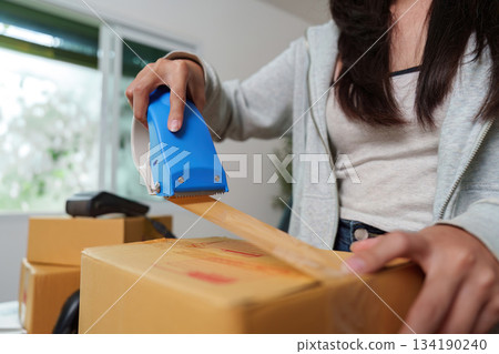 E-commerce: Sealing Package with Tape for Shipping E-commerce: Sealing Package with Tape for Shipping 134190240