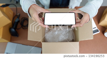 E-commerce: Unboxing Experience with Smartphone in Hand 134190253