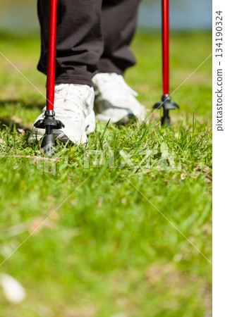 Nordic walking. Female legs hiking in the park. Nordic walking. Female legs hiking in the park. 134190324