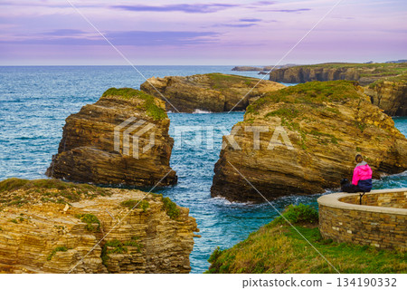 Woman visiting Cathedral Beach in Spain. 134190332