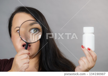 Woman investigating ingredients of medicines Woman investigating ingredients of medicines 134190987