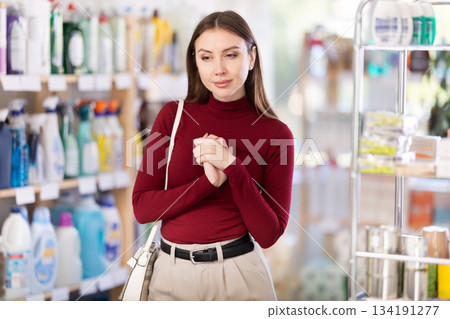 woman chooses household chemicals in a supermarket woman chooses household chemicals in a supermarket 134191277