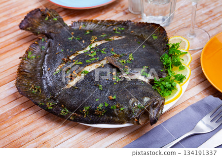 Baked flounder with parsley and lemon. Mediterranean cuisine closeup Baked flounder with parsley and lemon. Mediterranean cuisine closeup 134191337