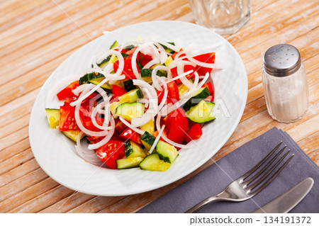 Summer salad from fresh tomatoes, cucumbers, onion 134191372