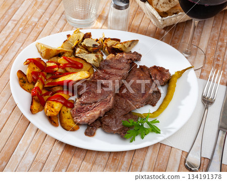 Delicious beef steak with baked potatoes and artichokes 134191378