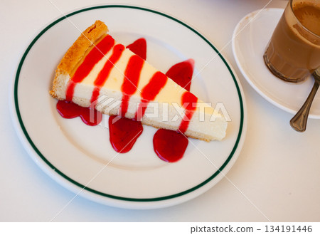 Slice of delicious classical cheesecake with fruity sauce served Slice of delicious classical cheesecake with fruity sauce served 134191446