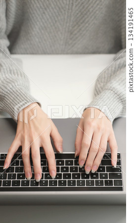Top view of woman's hands typing on laptop keyboard, close-up. Work, AI prompt, research, social networks, and remote education in a modern workspace. 134191465