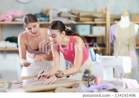 Two female designers drawing sketches in a workshop Two female designers drawing sketches in a workshop 134191496