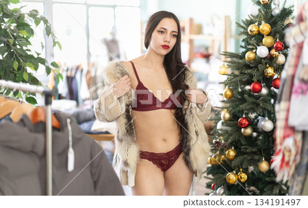 Young woman tries on lace lingerie and fur coat Young woman tries on lace lingerie and fur coat 134191497