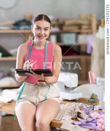 Woman designer use stylus to draw on graphics tablet 134191535