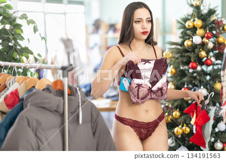 Young woman chooses underwear in clothing store Young woman chooses underwear in clothing store 134191563