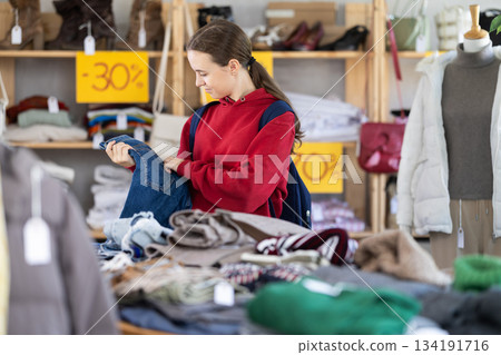 Teenage girl choosing jeans in clothing store 134191716