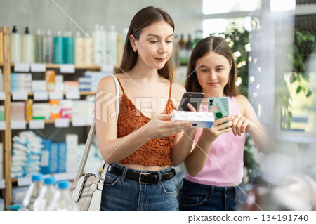 Daughter and mother in summer clothes scans code on ointment to check expiration date Daughter and mother in summer clothes scans code on ointment to check expiration date 134191740