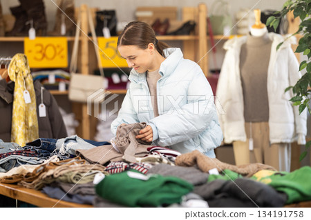 Teenage girl choosing woolen pants 134191758