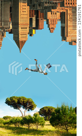 Bright poster of man falling between upside down skyscrapers and sunny green meadow. 134191761