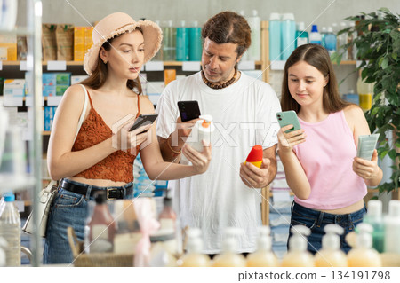 Family and teen girl in pharmacy scans QR code sunblock cream product 134191798