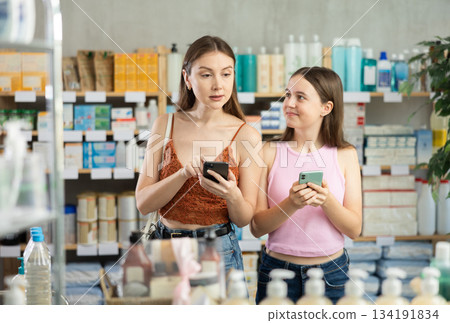 Woman and adolescence girl in pharmacy with phone 134191834