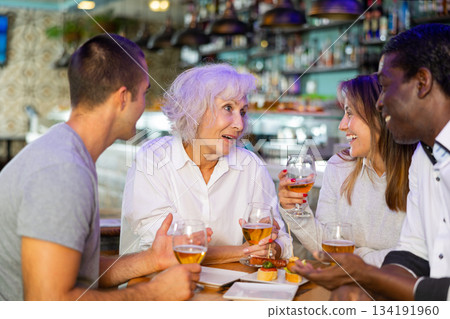 Happy diverse group having a conversation at a bar 134191960