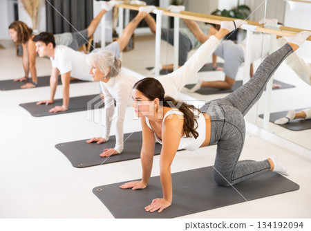 Group of different people doing exercises in gym Group of different people doing exercises in gym 134192094