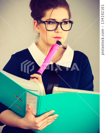 woman thinking holds file folder with documents woman thinking holds file folder with documents 134192161