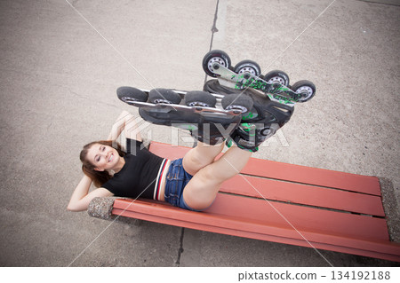 Crazy woman on bench wearing roller skates 134192188