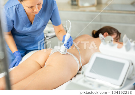 Professional beautician makes cryotherapy for rejuvenation woman body, anti aging procedure and shrink pores and repair damaged skin in salon 134192258