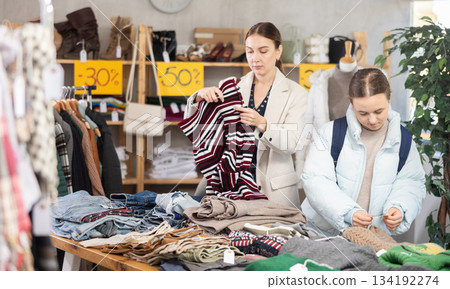 Adult woman and teenage girl choose trousers 134192274