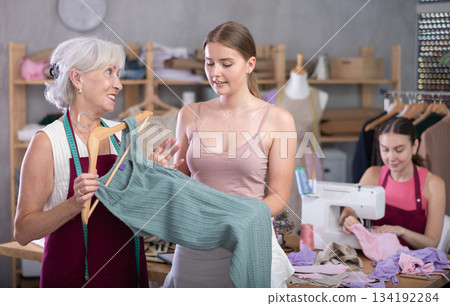 Mature female dressmaker showing a dress sample 134192284
