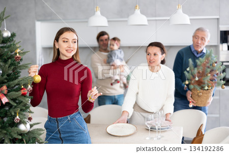 Woman decorating Christmas tree 134192286
