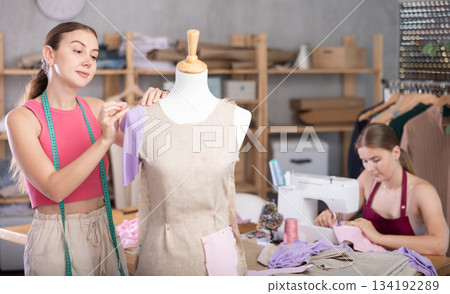 Adult woman sews female assistant working with mannequin 134192289