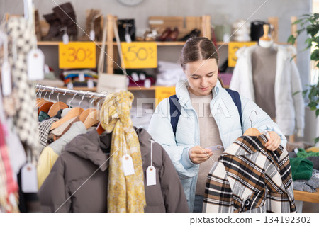 Teenage girl chooses coat in clothing store 134192302