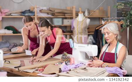 Mature head of cloth manufacturing sewing, two assistant drawing paper dress pattern by curves Mature head of cloth manufacturing sewing, two assistant drawing paper dress pattern by curves 134192342