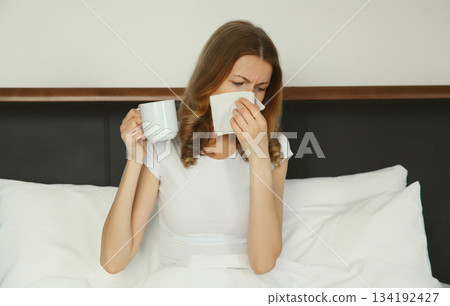 Sick exhausted young woman sneezing blow nose using tissue, unhealthy suffering girl feels unwell 134192427