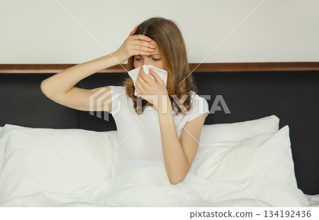 Sick exhausted young woman sneezing blow nose using tissue, unhealthy suffering girl feels unwell 134192436