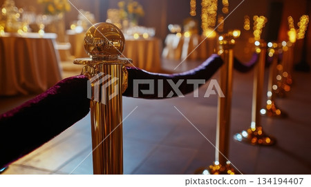Elegant event venue with golden ropes and floral decorations at night 134194407