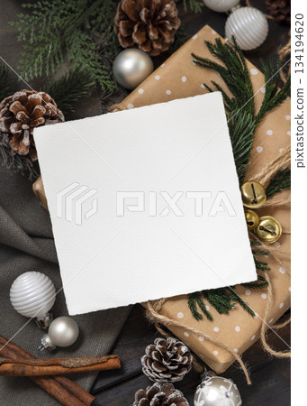 Card on wrapper Christmas present near pine cones, spices and fir twigs, top view. Holiday mockup Card on wrapper Christmas present near pine cones, spices and fir twigs, top view. Holiday mockup 134194620