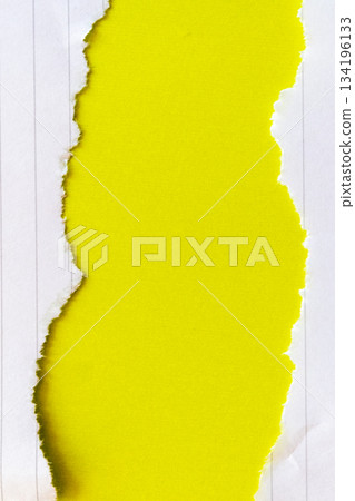 Ripped white paper with lined texture on a bright yellow background. The torn edge creates a contrast between the two colors. 134196133
