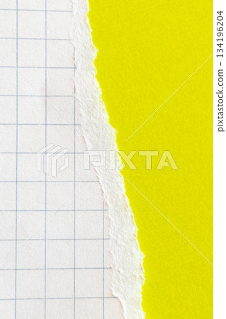 Ripped white paper with squared texture on a bright yellow background. The torn edge creates a contrast between the two colours. 134196204