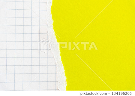 Ripped white paper with squared texture on a bright yellow background. The torn edge creates a contrast between the two colours. 134196205