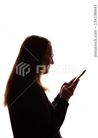Silhouette of young woman using smartphone on white background 134196645