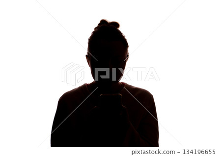 Silhouette young woman with hair up using smartphone, white background 134196655