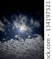 Night sky with the moon visible through the clouds 134197321